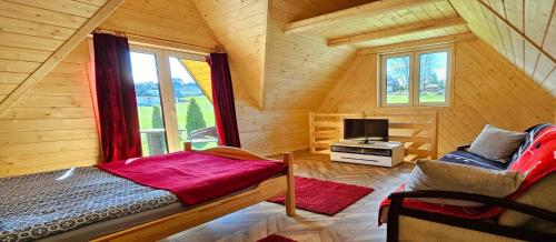 1 dormitorio con 1 cama y TV en una cabaña en ECO Domek z dużym ogrodem i widokiem, en Murzasichle