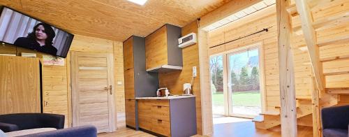 a kitchen in a wooden cabin with a tv on the wall at ECO Domek z dużym ogrodem i widokiem in Murzasichle