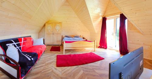 sala de estar con sofá rojo y cama en ECO Domek z dużym ogrodem i widokiem, en Murzasichle