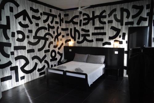 a bedroom with a bed and a wall with writing on it at Stupido Hotel Rimini in Rimini