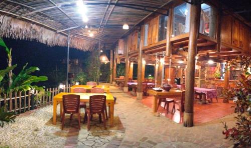a restaurant with wooden tables and chairs in a building at Pù Luông Happy Home in Hương Bá Thước