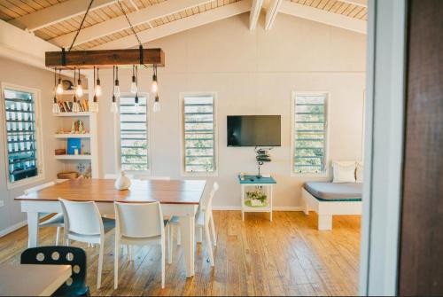 a dining room with a table and chairs and a tv at Ocean Front Villa 1 in Culebra
