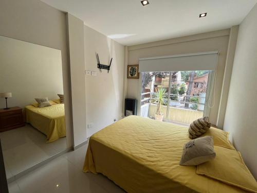 a bedroom with two beds and a large window at Departamento nuevo en San Bernardo in San Bernardo