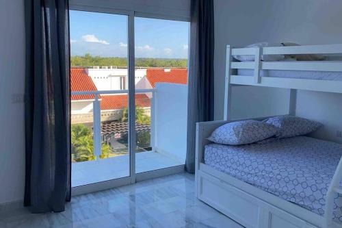Schlafzimmer mit Etagenbett und Balkon in der Unterkunft Playa Nueva Romana Penthouse in La Romana