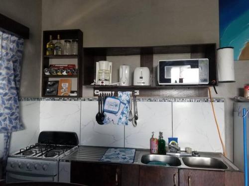 a small kitchen with a stove and a sink at Maui's View in Santa Elena