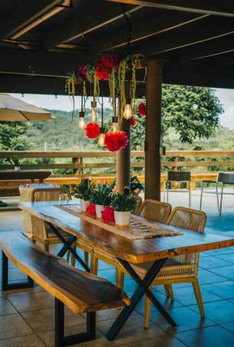 a long wooden table with chairs and flowers on it at Villa Tesoro at Carabali in Luquillo