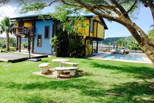 a picnic table in the grass in front of a building at Villa Tesoro at Carabali in Luquillo
