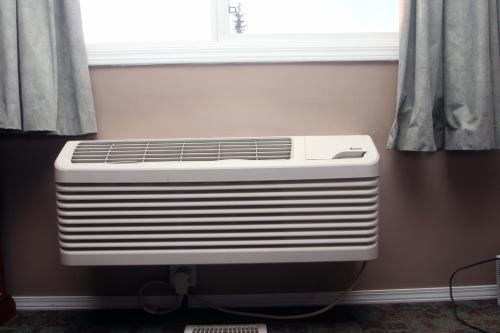 a white radiator in a room under a window at Castle Motel in Edson