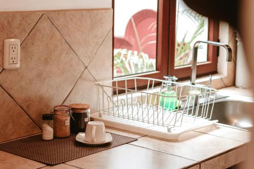 a dish rack sitting on a kitchen counter next to a sink at All Suite El Marques de Antigua in Antigua Guatemala