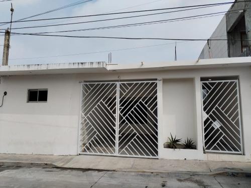 un edificio blanco con una puerta corredera. en Casa LUNA ven y disfruta, en Veracruz