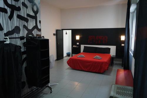 una camera con un letto rosso con un lenzuolo rosso di Stupido Hotel Rimini a Rimini