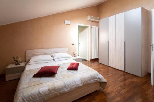 a bedroom with a large bed with two red pillows on it at Tranquil Elegance in Parma in Parma