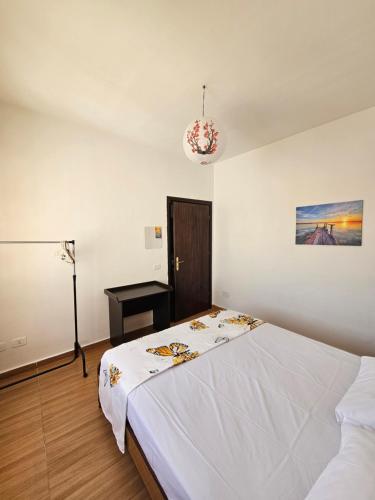 1 dormitorio con 1 cama blanca y 1 lámpara en COASTAL APARTMENT 9th FLOUR, en Durrës