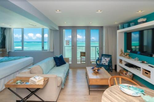 a living room with a couch and a table at Enchanted Honeymoon Isla Verde Beachfront in San Juan