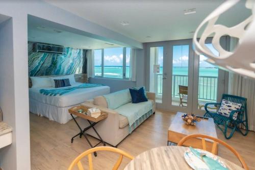 een slaapkamer met een bed en een woonkamer met een bank bij Enchanted Honeymoon Isla Verde Beachfront in San Juan