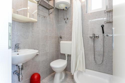 a bathroom with a toilet and a sink and a shower at Apartments by the sea Podaca, Makarska - 2783 in Podaca