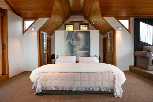 ein Schlafzimmer mit einem großen Bett und einer Holzdecke in der Unterkunft Eagles Nest in Russell
