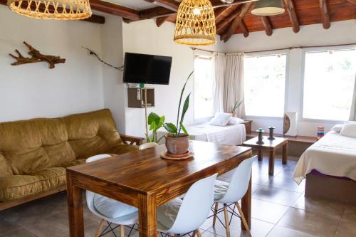 uma sala de estar com um sofá e uma mesa em Punta Piedra cabañas & suites em Los Reartes