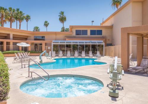 パーム・スプリングスにあるWorldMark Palm Springs - Plaza Resort and Spaのスイミングプール(椅子付)と建物