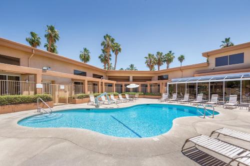 een zwembad met stoelen en een gebouw bij WorldMark Palm Springs - Plaza Resort and Spa in Palm Springs