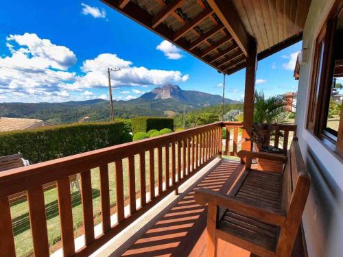 une terrasse couverte avec un banc et une vue sur la montagne dans l'établissement Mansão em Pedra Azul! Exclusividade na região, à Domingos Martins