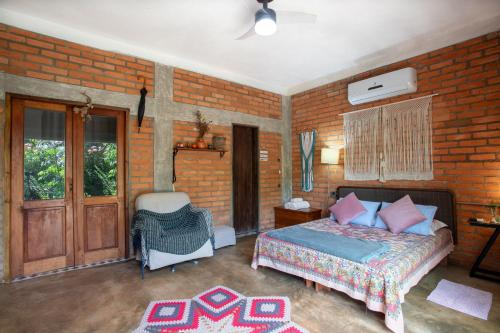 沙帕達－杜斯吉馬朗伊斯的住宿－Espaço Aricá，一间卧室设有一张床和砖墙