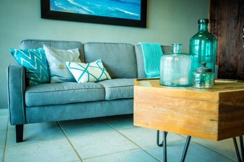 a living room with a couch and a wooden table at Enchanted Jewel 9 Beachfront Pool in Luquillo
