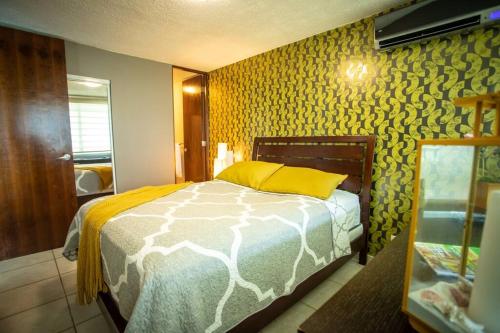 a bedroom with a bed with a yellow pillow at Enchanted Jewel 9 Beachfront Pool in Luquillo