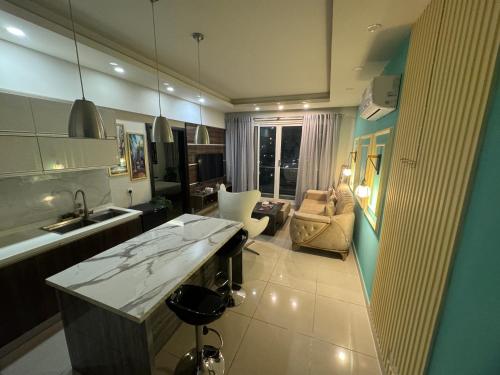 a kitchen with a sink and a living room at The Designer Den opposite to Centaurus mall in Islamabad