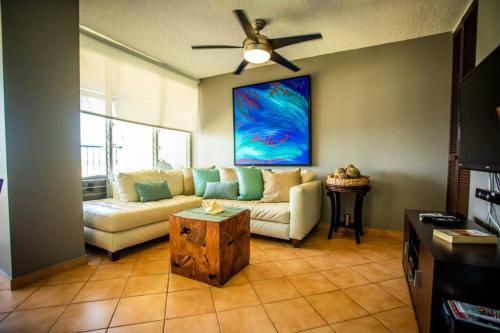 a living room with a couch and a ceiling fan at Enchanted Jewel 39 Beachfront Pool in Luquillo