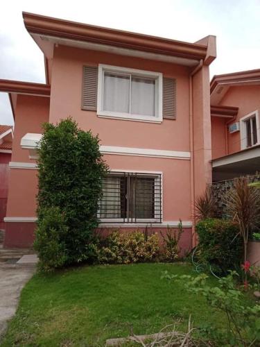 a pink house with a lawn in front of it at Al Manzil in General Santos