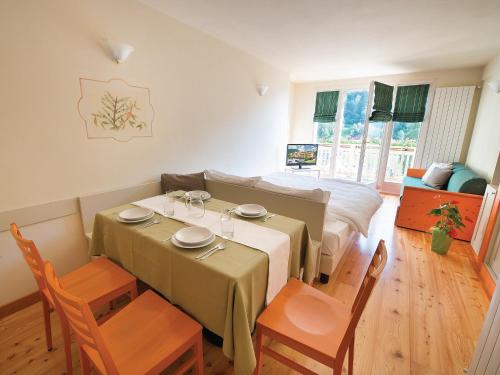 a room with a table and chairs and a bed at Residence Club Ponte Di Legno in Ponte di Legno