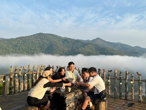 a group of people sitting around a table on a rock at THIÊN HƯƠNG Homestay Măng Đen in Kon Von Kla