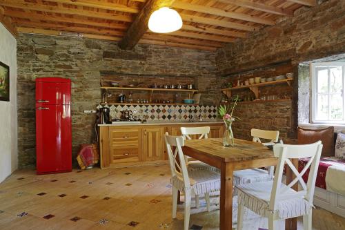 a kitchen with a wooden table and a red refrigerator at Nisanyan Hotel in Selcuk