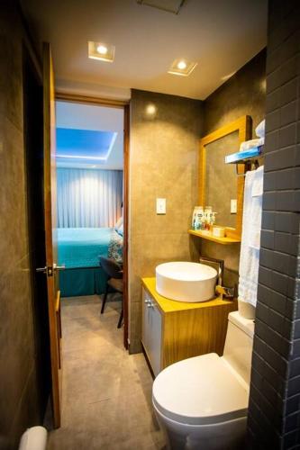 a bathroom with a white toilet and a sink at Enchanted 8 Jewel Luquillo Beachfront - Pool in Luquillo