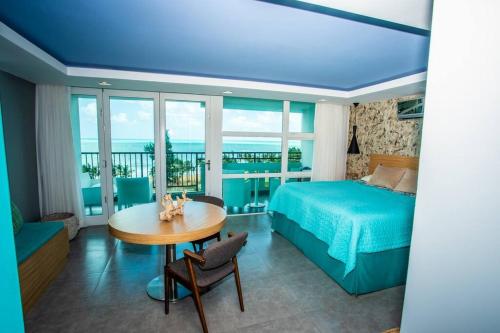 1 dormitorio con 1 cama y 1 mesa y 1 dormitorio con 1 cama y vistas en Enchanted 8 Jewel Luquillo Beachfront - Pool, en Luquillo