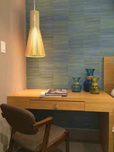 a desk with vases and a lamp and a chair at Enchanted 17 Jewel Beachfront Luquillo -Pool in Luquillo