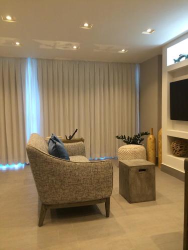 a living room with a chair and a television at Enchanted 17 Jewel Beachfront Luquillo -Pool in Luquillo