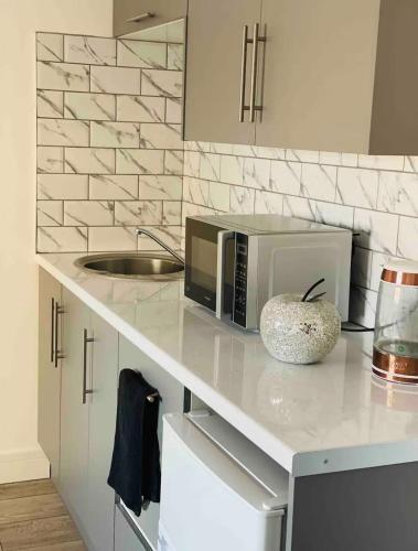 a kitchen with a counter with a microwave on it at Roomello luxury City Studios in Peterborough