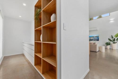 a room with a closet with wooden shelves at Beachmont Bliss Palm Cove in Palm Cove