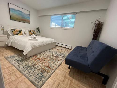 1 dormitorio con 1 cama y 1 silla azul en Beautiful Vancouver Special Home en Vancouver