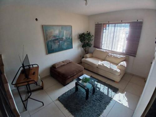 a living room with a couch and a table at Vivienda completa. Privada con acceso controlado. FACTURAMOS in Hermosillo