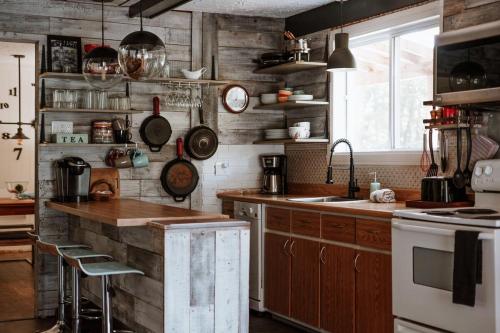 a kitchen with wooden walls and a counter with a sink at Chalet rétro Avec Spa in Chertsey