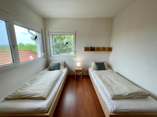 2 camas en una habitación con 2 ventanas en Belle Vue, en Cserszegtomaj