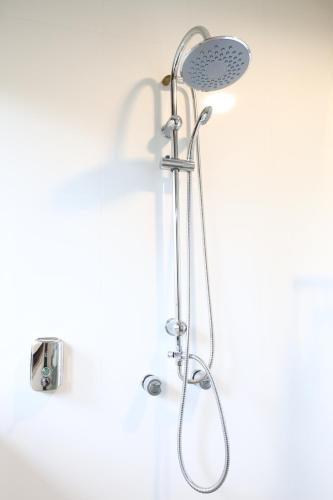 a shower with a shower head in a bathroom at Aldeia Flor de Liz - Pedra Azul in Pedra Azul