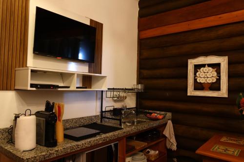 a hotel room with a sink and a television on a wall at Aldeia Flor de Liz - Pedra Azul in Pedra Azul