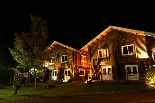 a couple of wooden buildings at night at Aldeia Flor de Liz - Pedra Azul in Pedra Azul
