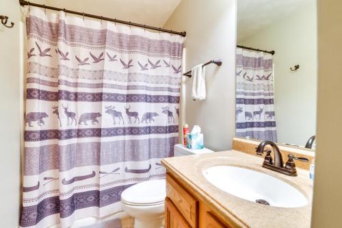 a bathroom with a sink and a shower curtain at Somerset Townhome with Deck Less Than 2 Mi to Ski Lift! in Champion