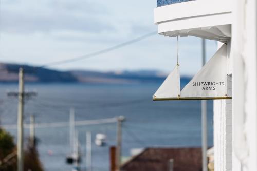 a sign on a building with a view of the water at Shipwrights Arms Hotel in Hobart