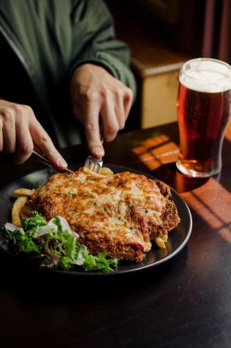 a person eating a piece of food on a plate at Shipwrights Arms Hotel in Hobart